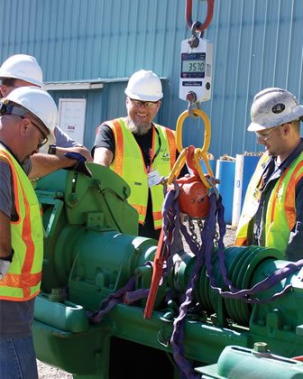 Personal pesando equipos industriales con báscula de grúa y dinamómetro